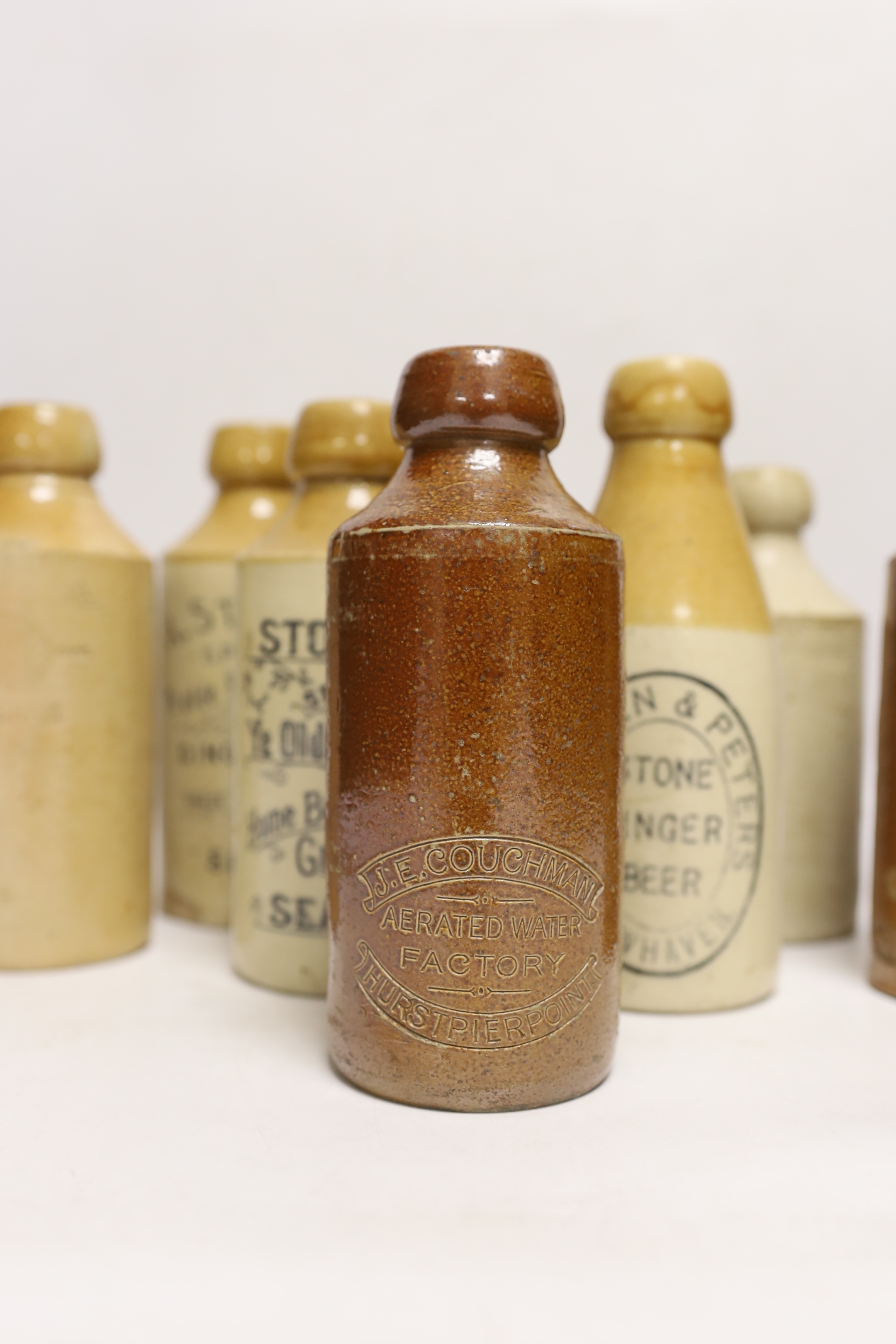 Early 20th century stoneware ginger beer bottles, one Hurstpierpoint, one Horsham, two Seaford and four others